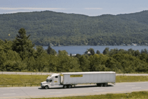 An image displays a white trucking trailer that is carrying goods