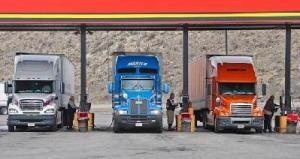 Three Semi trucks standing at oil stations for refueling