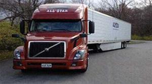 Red and white colored flat bed trucking company moving on the highway is shown in the image